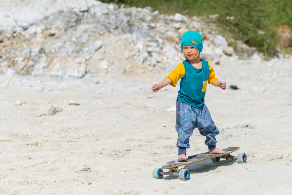 Kind auf Skatebord in der Natur